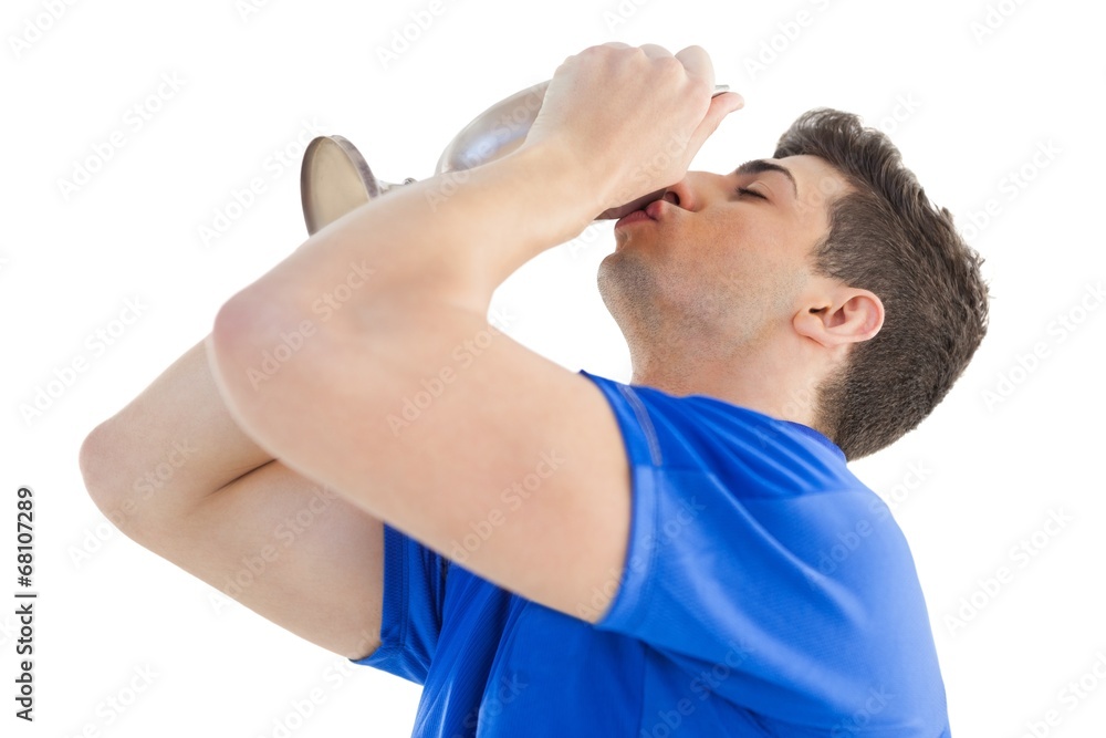 Football player in blue jersey kissing winners cup Football player in blue jersey kissing winners cup