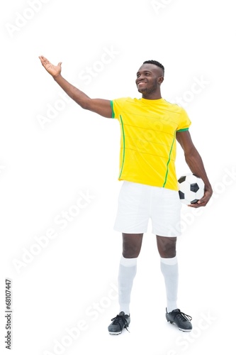 Fototapeta Naklejka Na Ścianę i Meble -  Football player in yellow standing with the ball