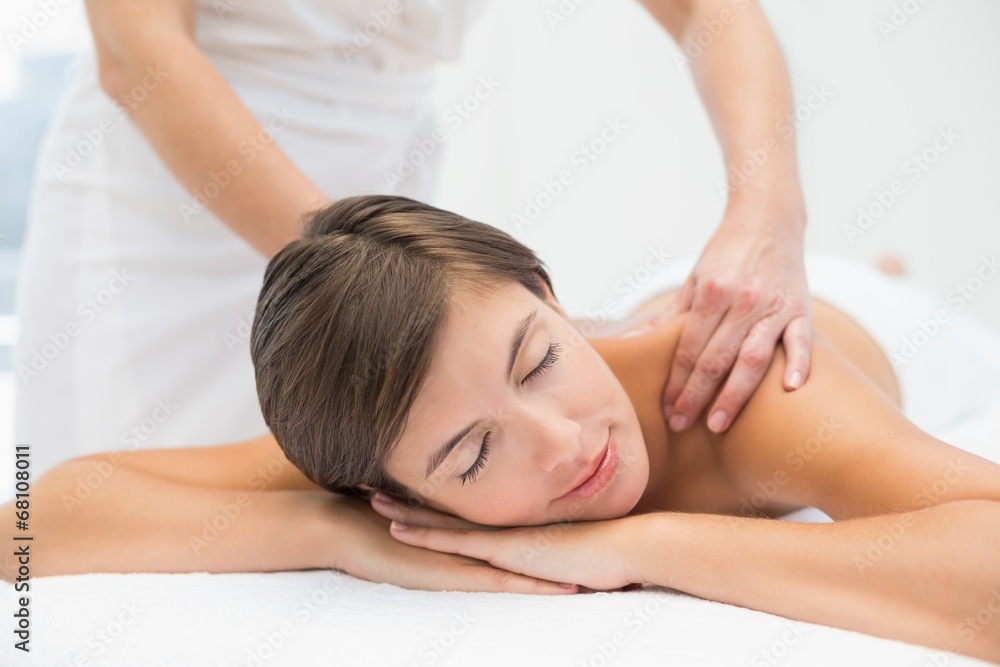 Attractive woman receiving shoulder massage at spa center Attractive woman receiving shoulder massage at spa center