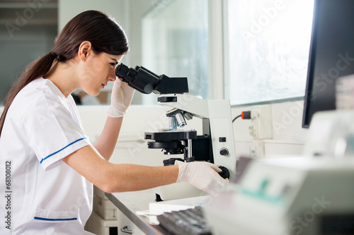 Female Scientist Looking Through Microscope