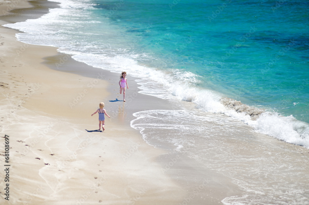 Two little sisters having fun on a beach Two little sisters having fun on a beach