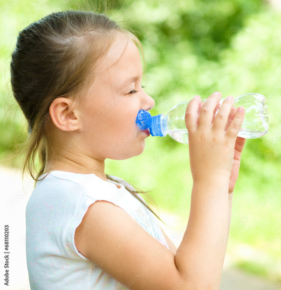 Cute girl drinks water from a plastic bottle Cute girl drinks water from a plastic bottle