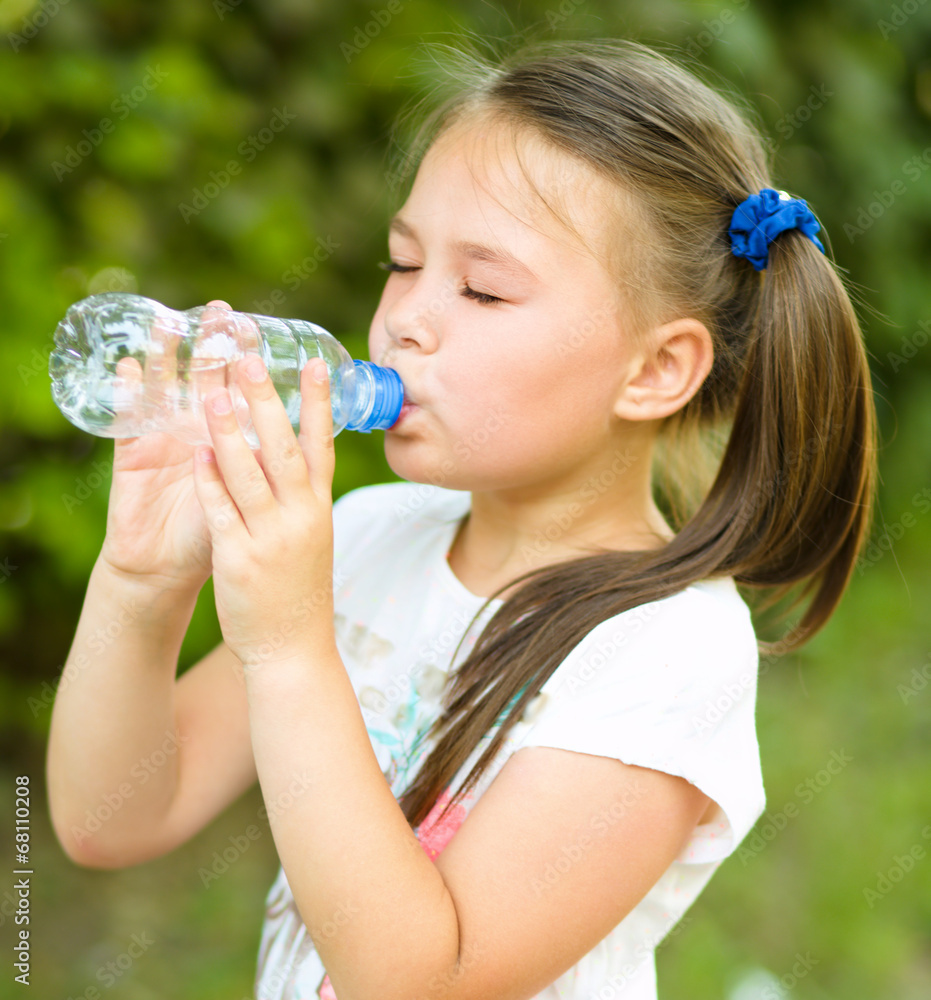 Cute girl drinks water from a plastic bottle Cute girl drinks water from a plastic bottle