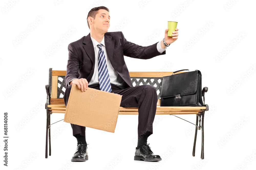 Broke businessman holding a cup and blank banner Broke businessman holding a cup and blank banner