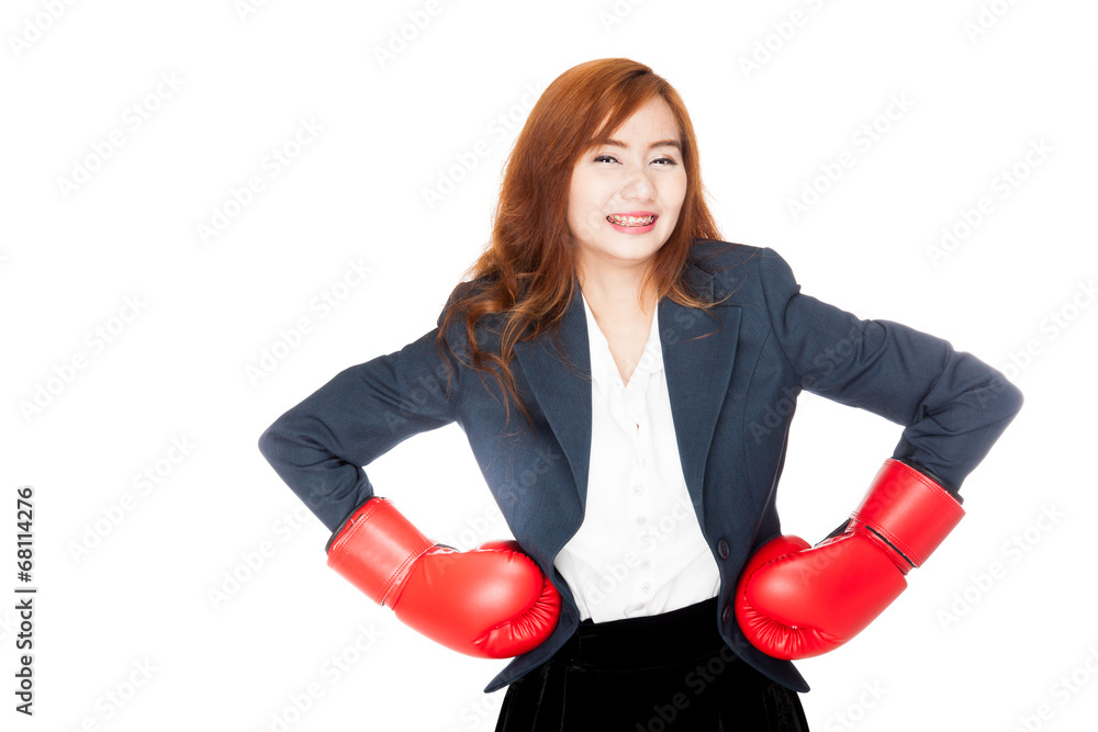 Asian businesswoman arms akimbo with boxing glove Asian businesswoman arms akimbo with boxing glove