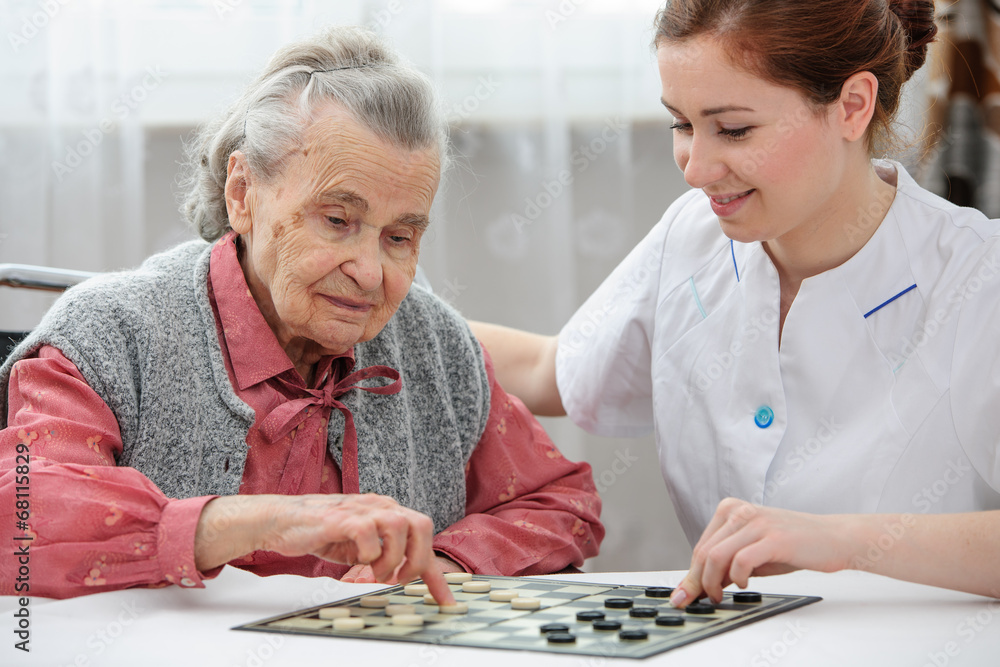 Fototapeta premium Senior woman playing checkers