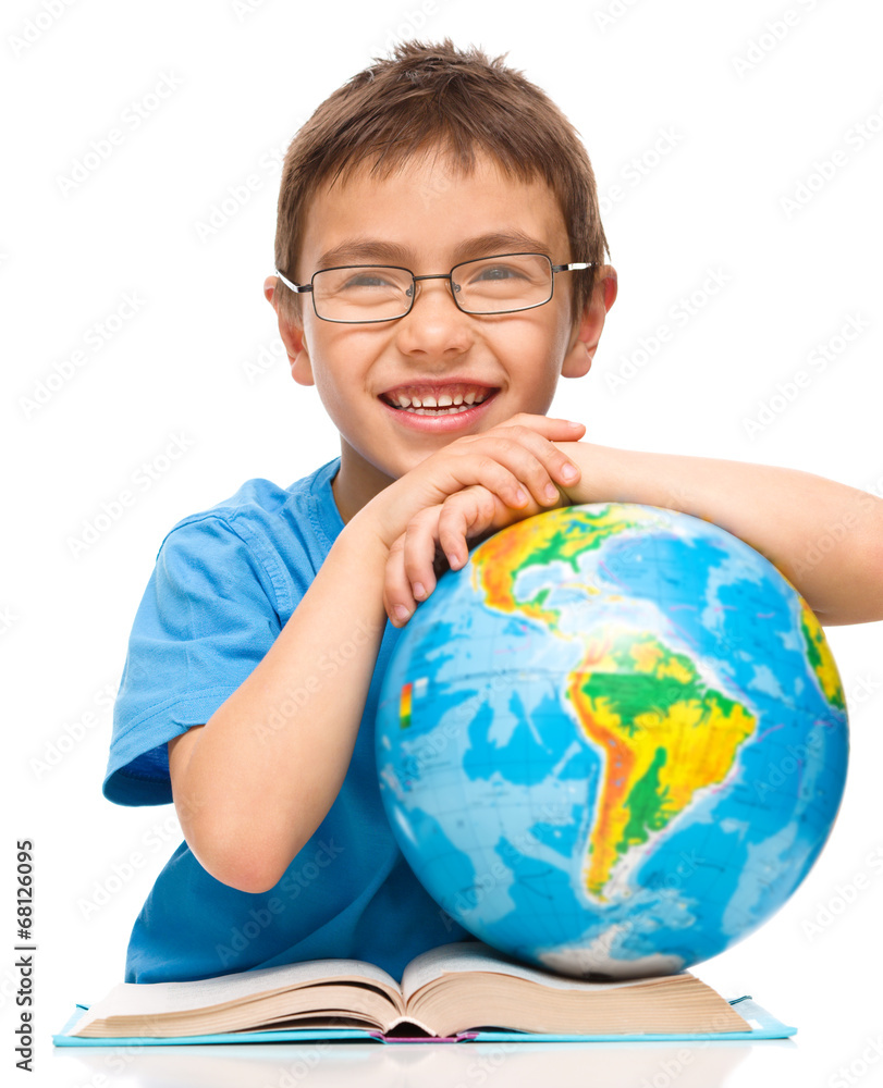 Little boy is examining globe