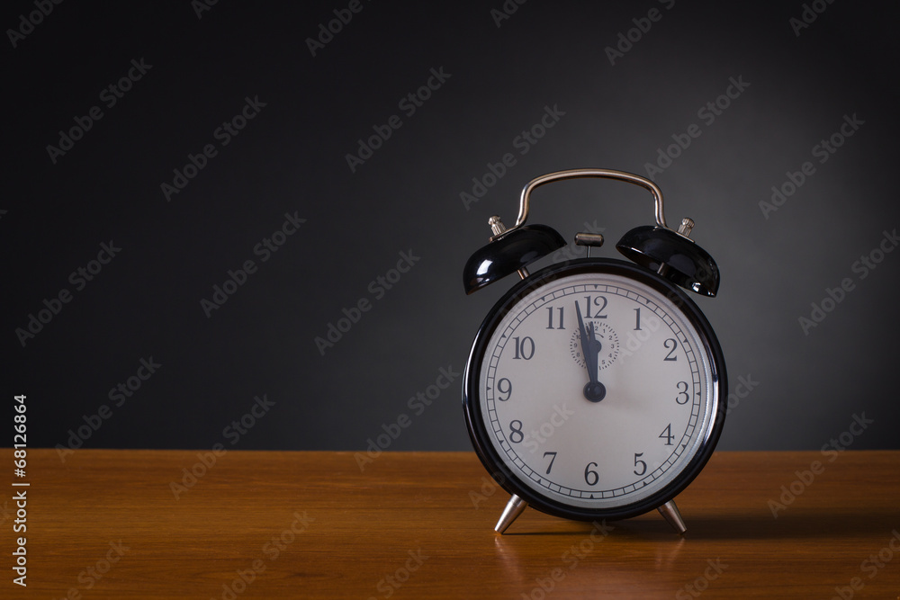 Black alarm clock on a dark background. Black alarm clock on a dark background.