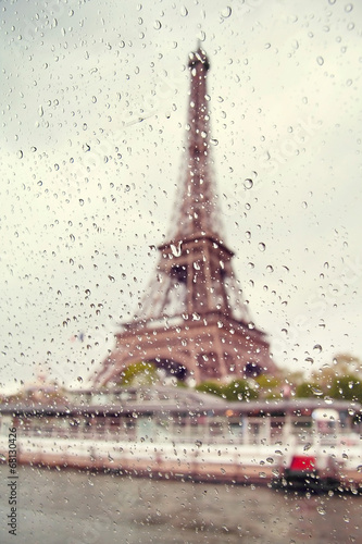 View on the Eiffel Tower through the window with rain drops.