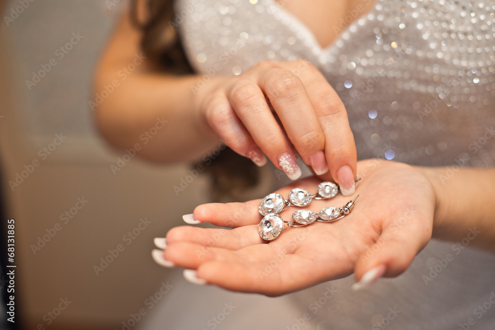 Earrings from pearls in hands. Earrings from pearls in hands.