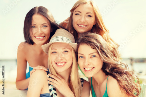 group of smiling girls in cafe on the beach