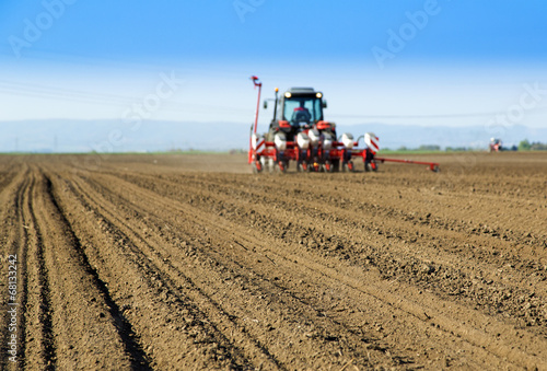 Farmer in tractor sowing crops at field