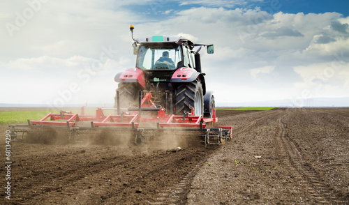 Photo Farmer in tractor preparing land for sowing