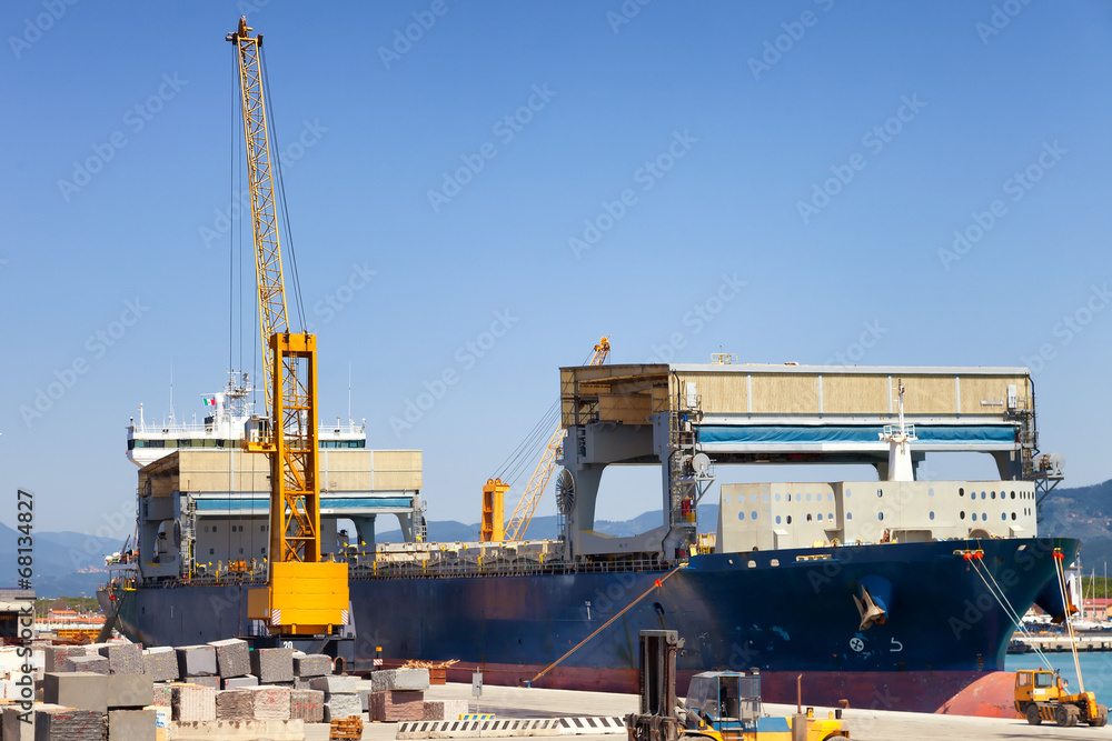 loading cargo ship docked in industrial harbor loading cargo ship docked in industrial harbor