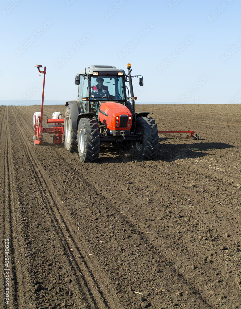 Farmer in tractor sowing corn maize crops Farmer in tractor sowing corn maize crops
