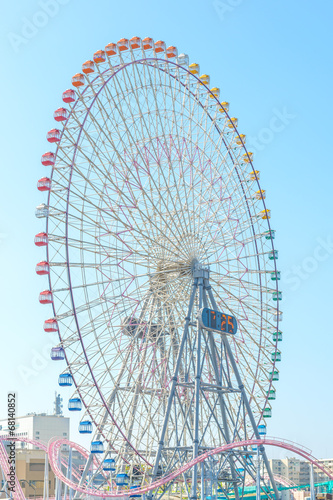 A big ferris wheel under bright blue sky.