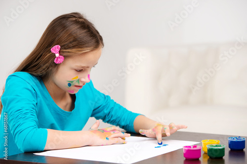 little girl drawing pictures with finger.