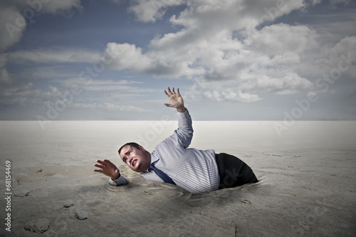 Obraz na płótnie business man who is sinking in a desert