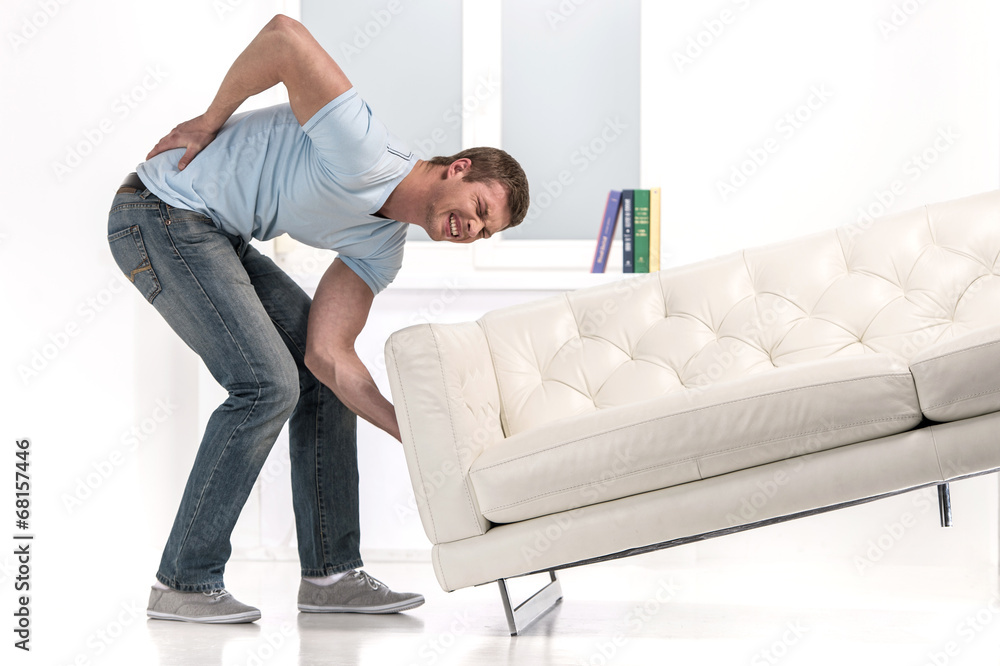 Handsome man lifting sofa and feeling pain. Handsome man lifting sofa and feeling pain.