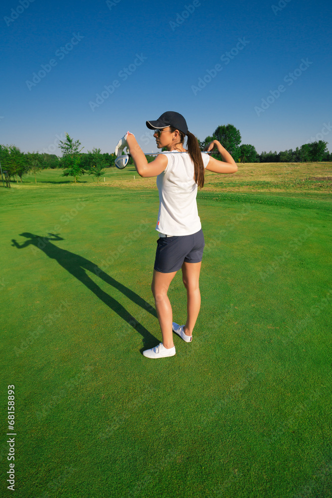 Attractive young woman playing golf