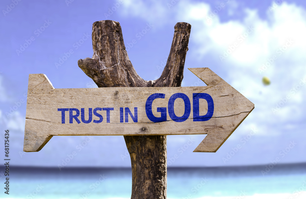 Trust in God wooden sign with a beach on background