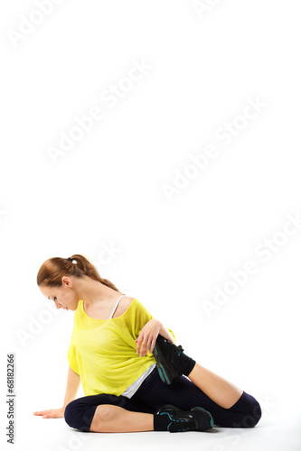 young sporty girl doing stretching exercises sitting