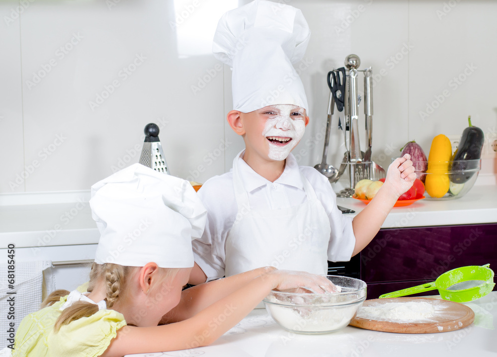 Happy little boy and girl baking in the kitchen Happy little boy and girl baking in the kitchen