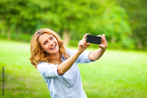 Nice woman taking pictures with smartphone photo