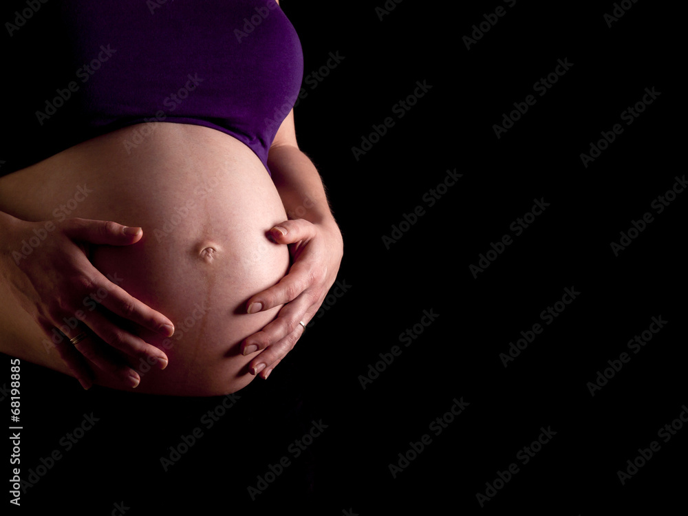 36 weeks pregnant young woman holding her naked belly 36 weeks pregnant young woman holding her naked belly