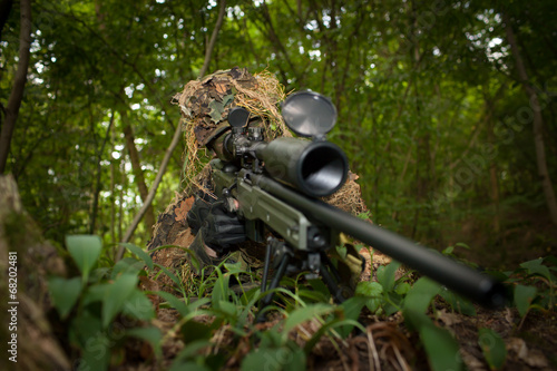 Masked sniper is aiming at the target during the mission photo