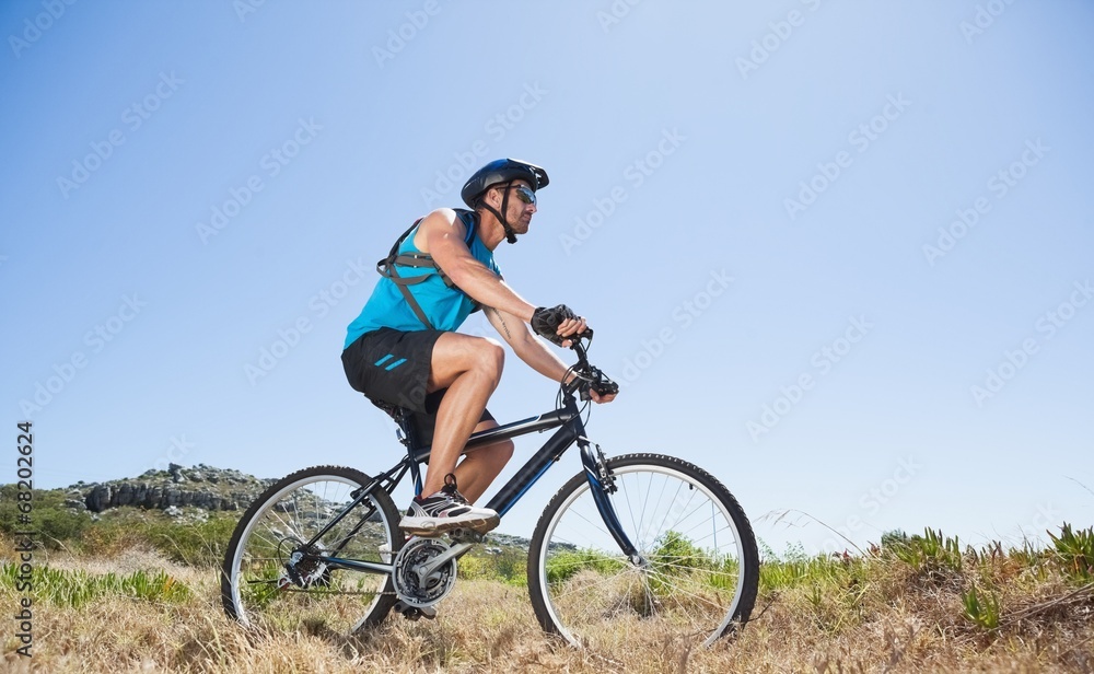 Fit cyclist riding in the countryside Fit cyclist riding in the countryside