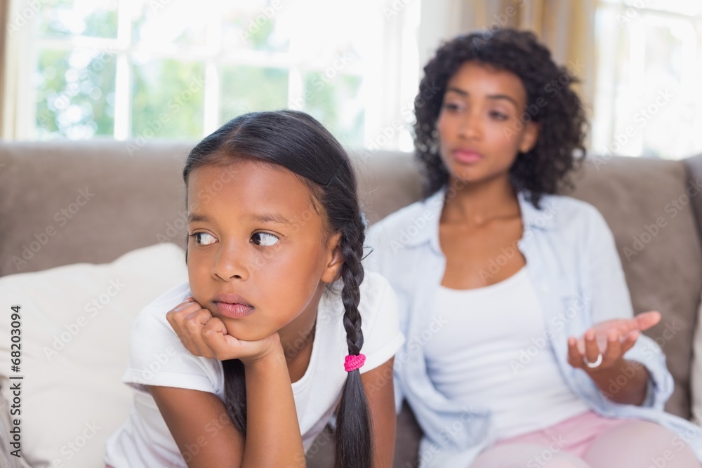 Pretty mother sitting on couch after an argument with daughter Pretty mother sitting on couch after an argument with daughter