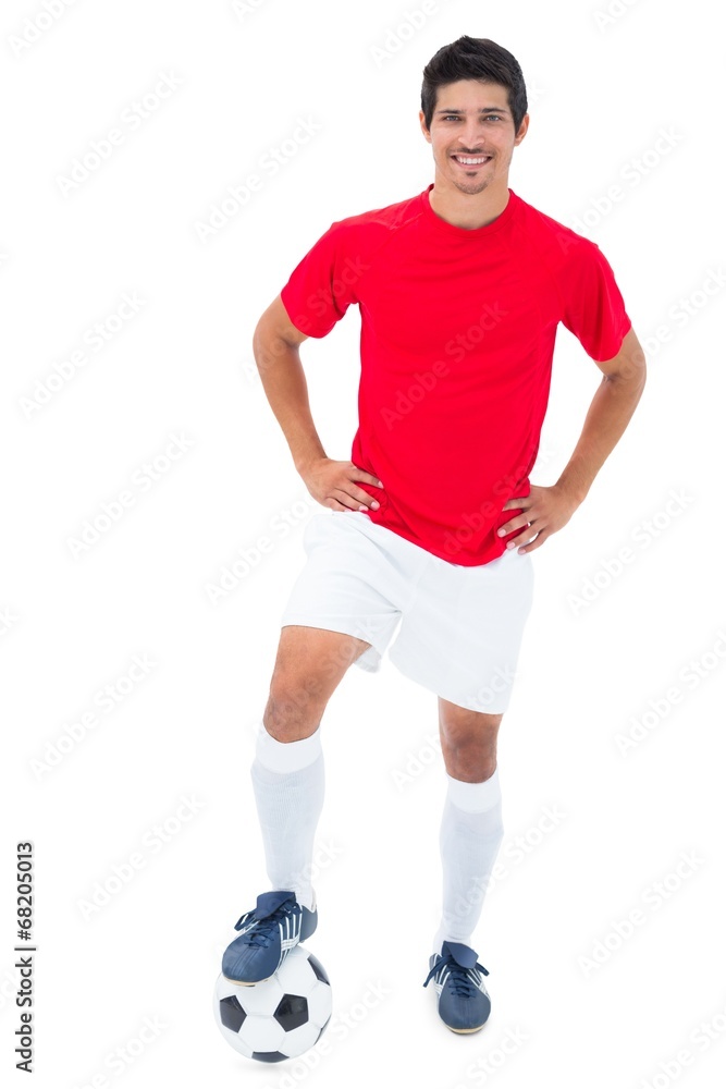 Football player in red standing with ball Football player in red standing with ball