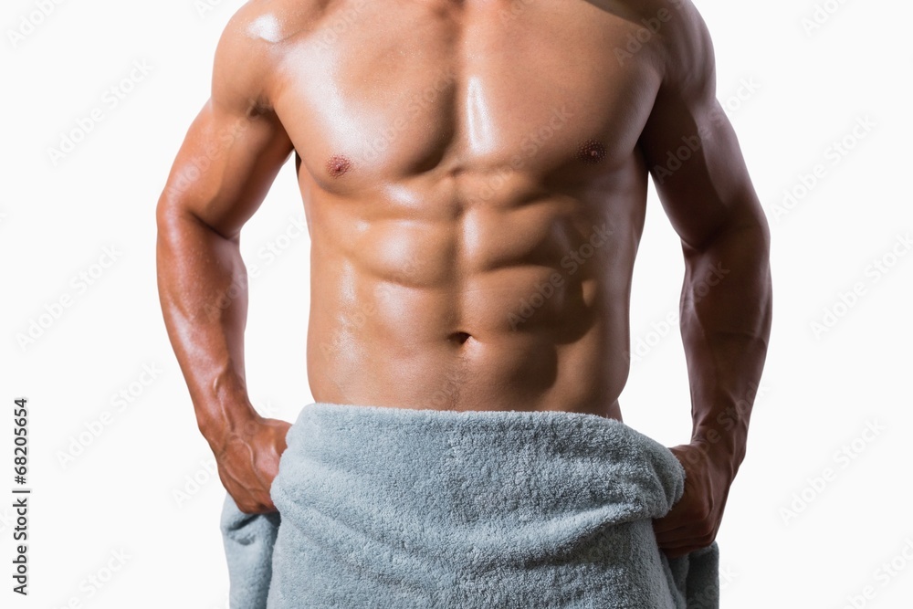 Mid section of a shirtless muscular man wrapped in towel