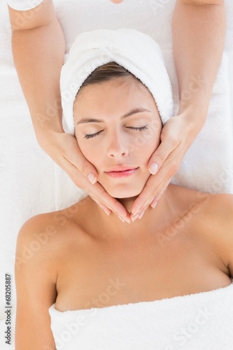 Attractive woman receiving facial massage at spa center