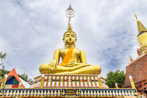 big golden buddha statue sitting at thai temple