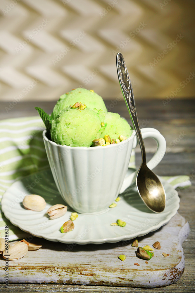 Tasty pistachio ice cream in cup on wooden table Tasty pistachio ice cream in cup on wooden table