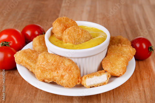 Chicken nuggets with sauce on table close-up
