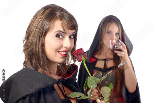 two young women in disguise halloween with a glass of blood and