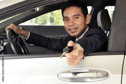 Asian businessman as driver giving a car key © Atstock Productions