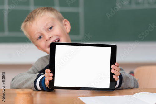 lachender junge in der schule zeigt tablet-pc
