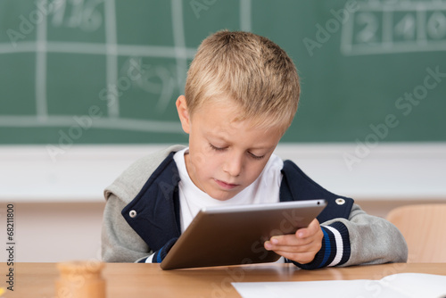 kleiner junge schaut konzentriert auf tablet-pc