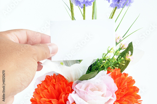 Hand holding empty tag card on flower bouquet