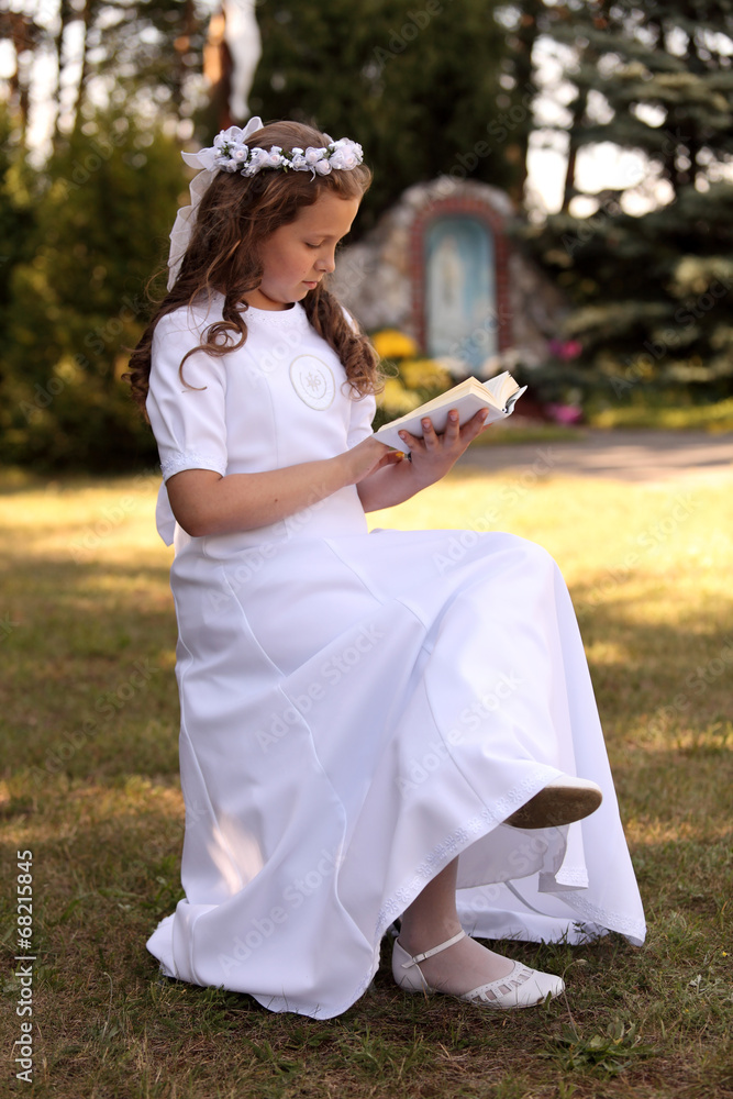Dziewczynka w białej sukni czyta książeczkę. - obrazy, fototapety, plakaty 