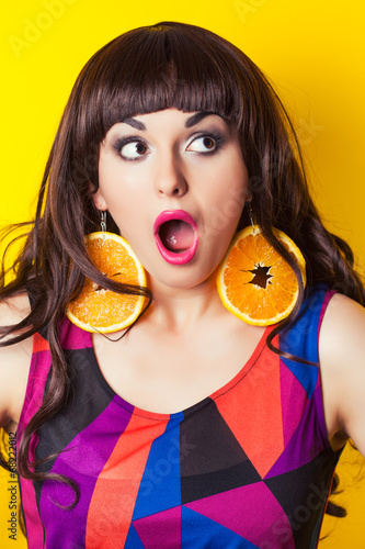 beautiful young woman wearing earrings made from orange against