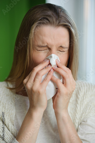 Woman blowing runny nose - Cold flu illness - vertical image