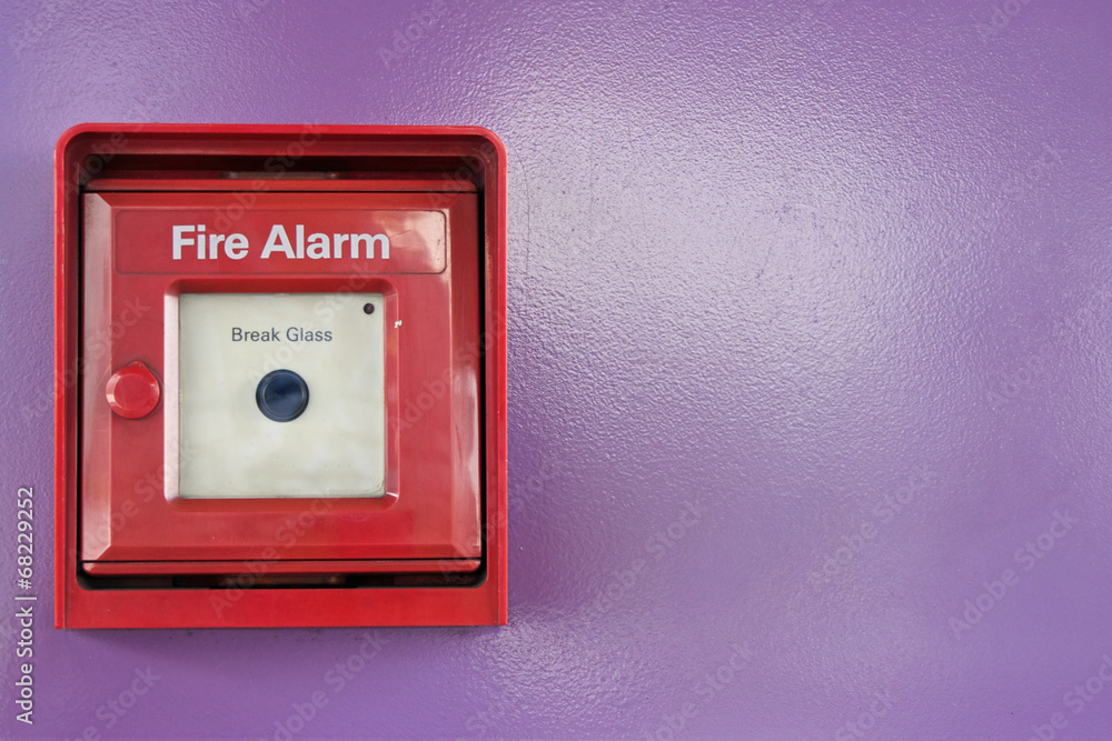 Red box of fire alarm on violet wall Red box of fire alarm on violet wall