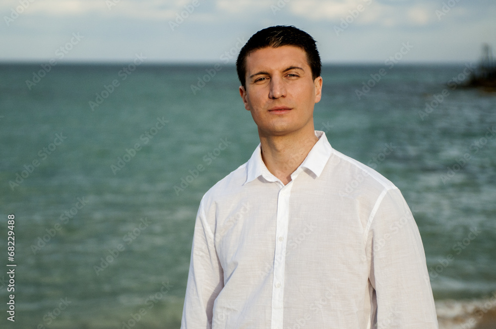 Ragazzo in camicia cammina in riva al mare Ragazzo in camicia cammina in riva al mare