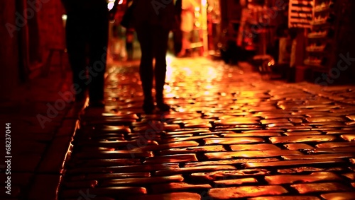 People walking on dark street.