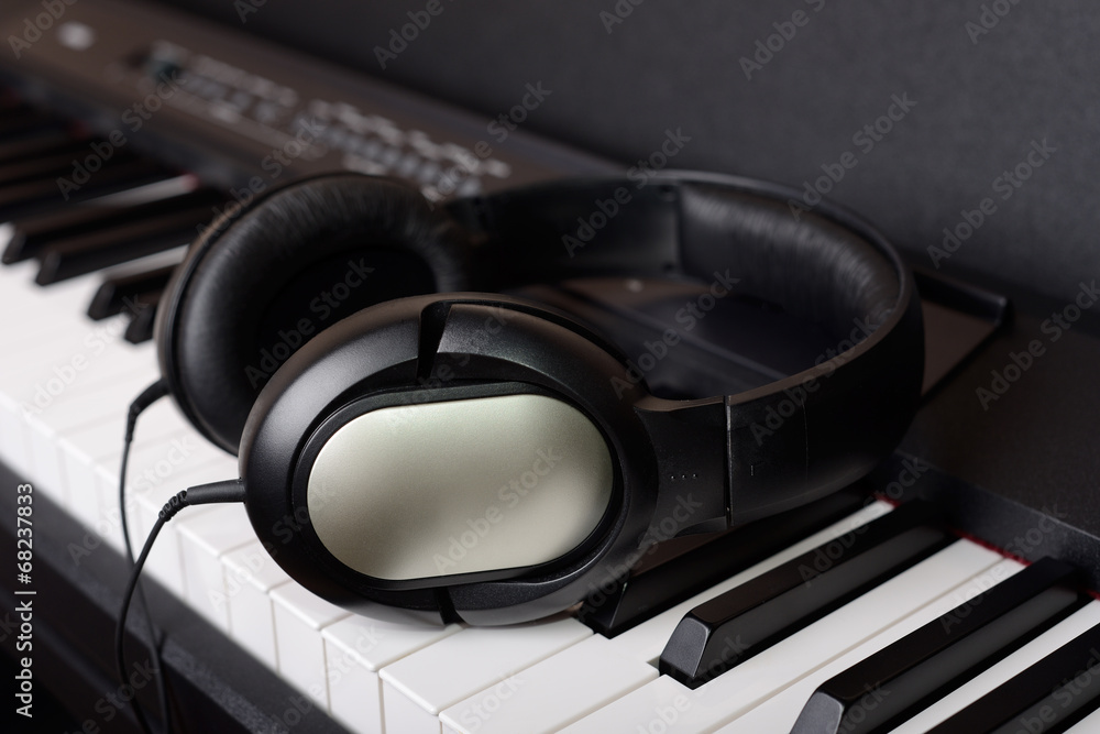Close-up headphones on piano keyboard Close-up headphones on piano keyboard